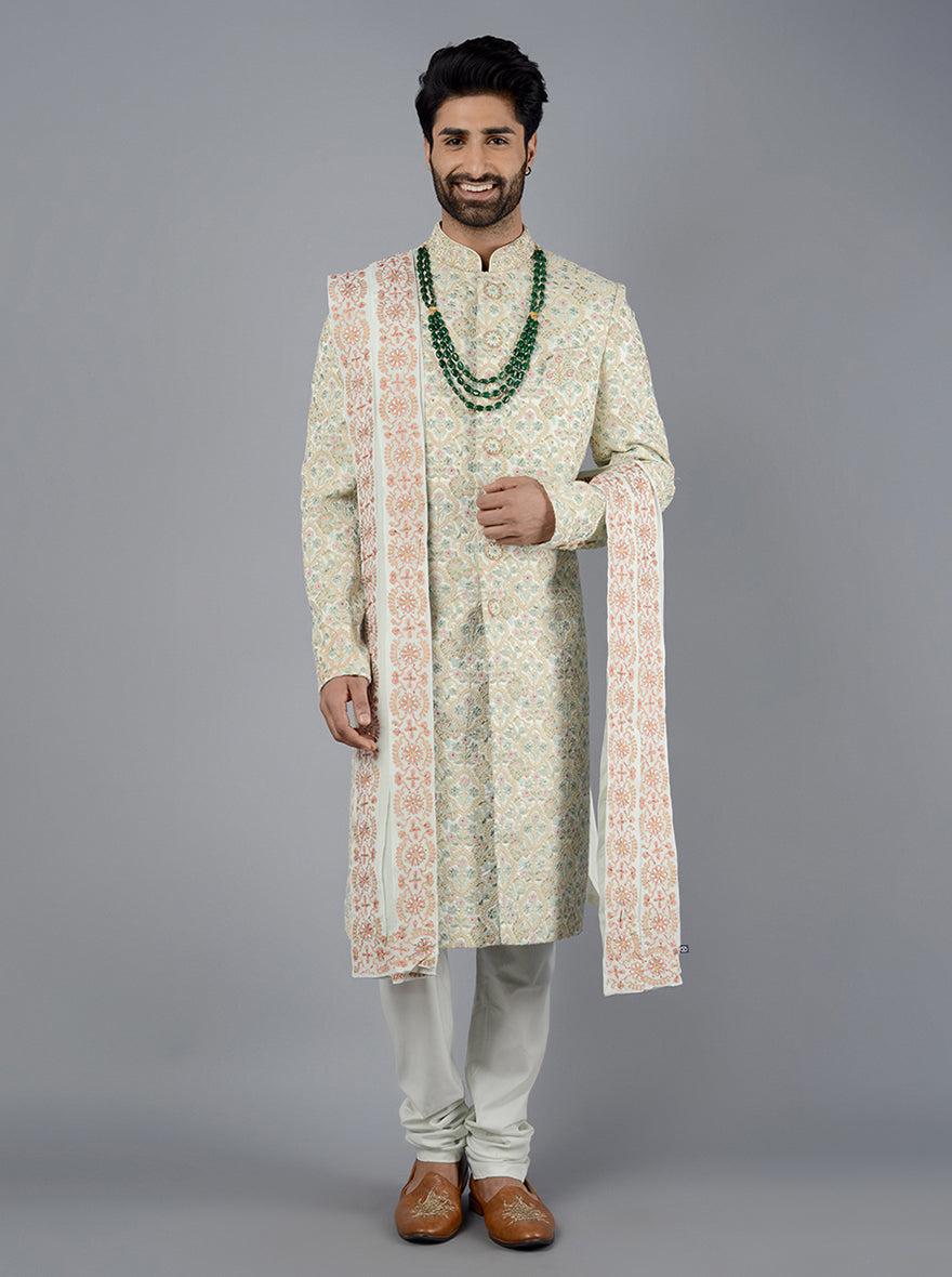 Detailed embroidery and luxurious fabric make this cream and sage green sherwani a standout choice.