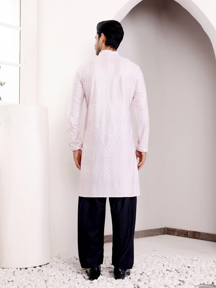 Light pink kurta set for men with delicate handwoven motifs and Chikankari embroidery, perfect for special occasions.