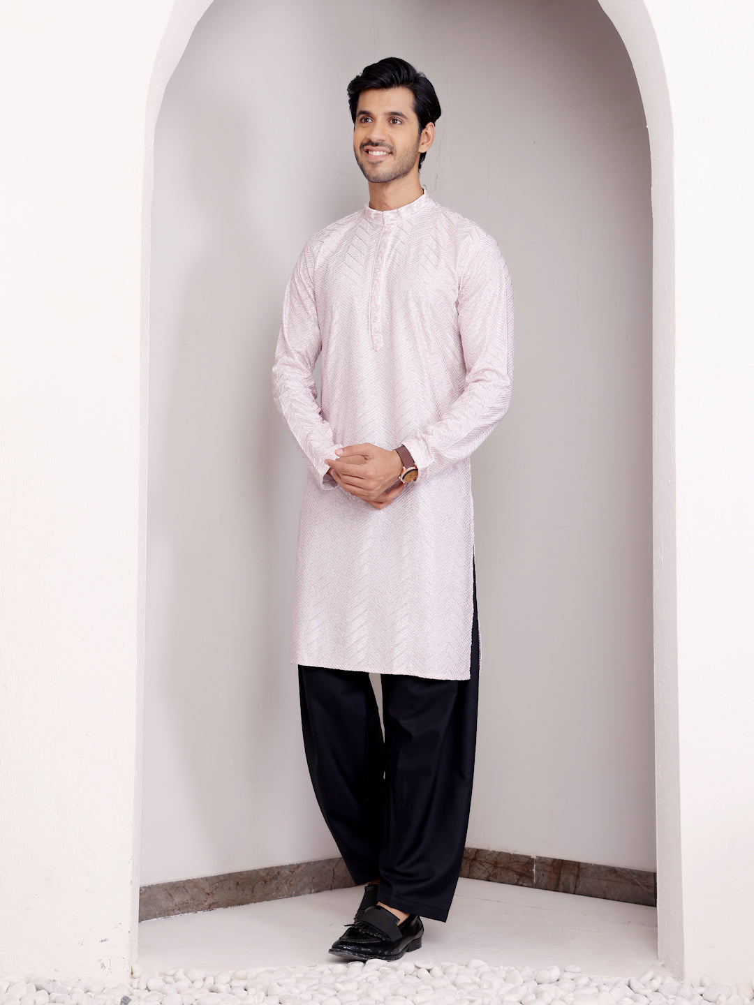 Men’s light pink kurta set featuring intricate handwoven motifs and Chikankari embroidery, perfect for celebrations.