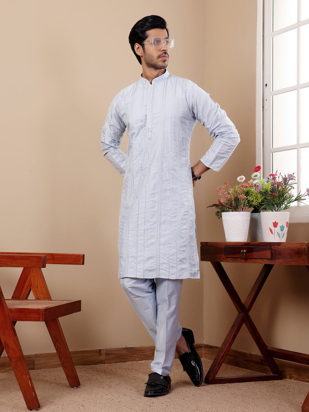 Men’s light blue kurta set with handwoven patterns on neckline and sleeves.