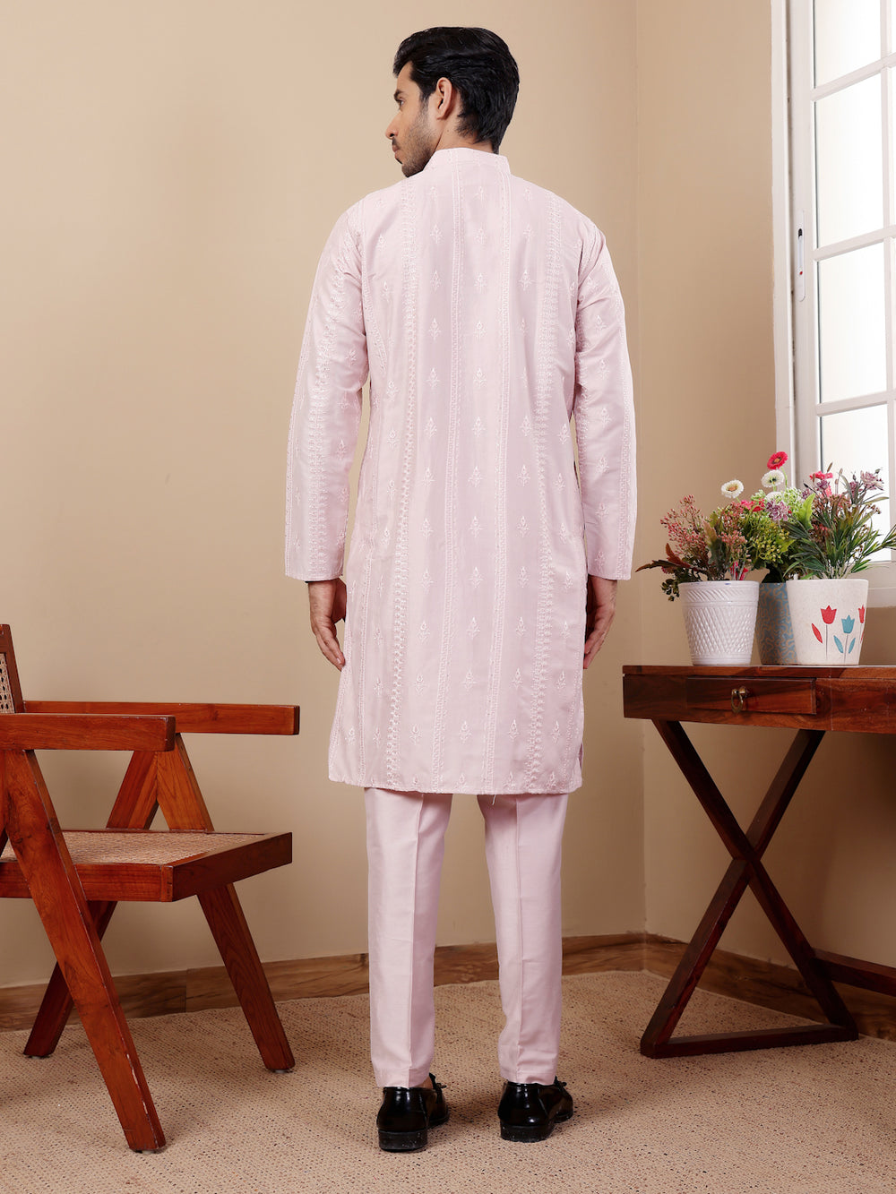 Traditional light pink cotton kurta set for men showcasing handcrafted motif detailing.