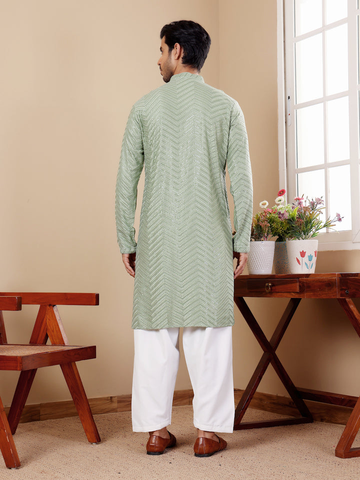 Pastel green kurta set for men featuring intricate handwoven motifs and Chikankari embroidery, perfect for festive occasions.