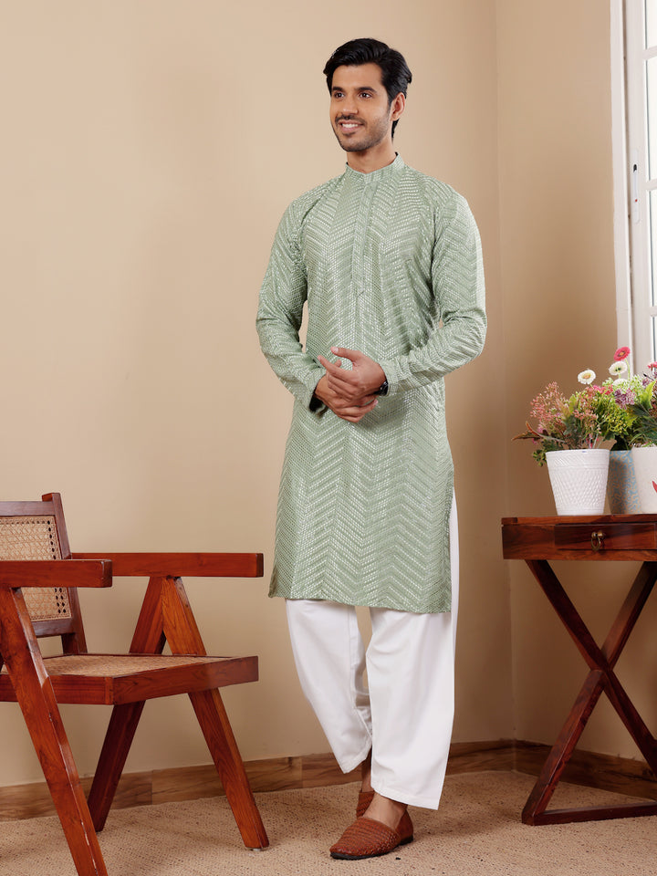 Men’s pastel green kurta set with handwoven motifs and Chikankari embroidery, ideal for celebrations.