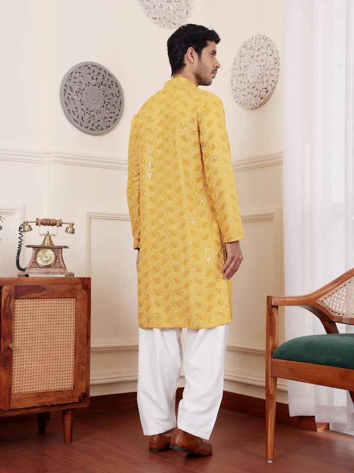 Men’s yellow kurta featuring floral Chikankari embroidery and art silk bottoms.