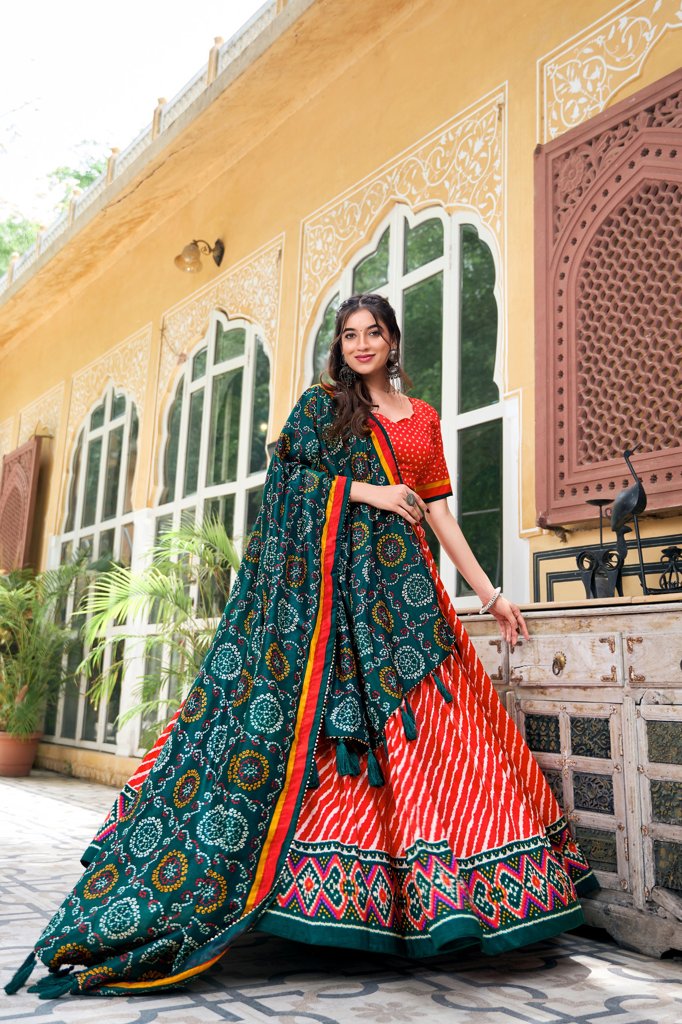 Beautiful red Tussar silk lehenga with Leheriya pattern and Patola detailing, ideal for bridal wear.