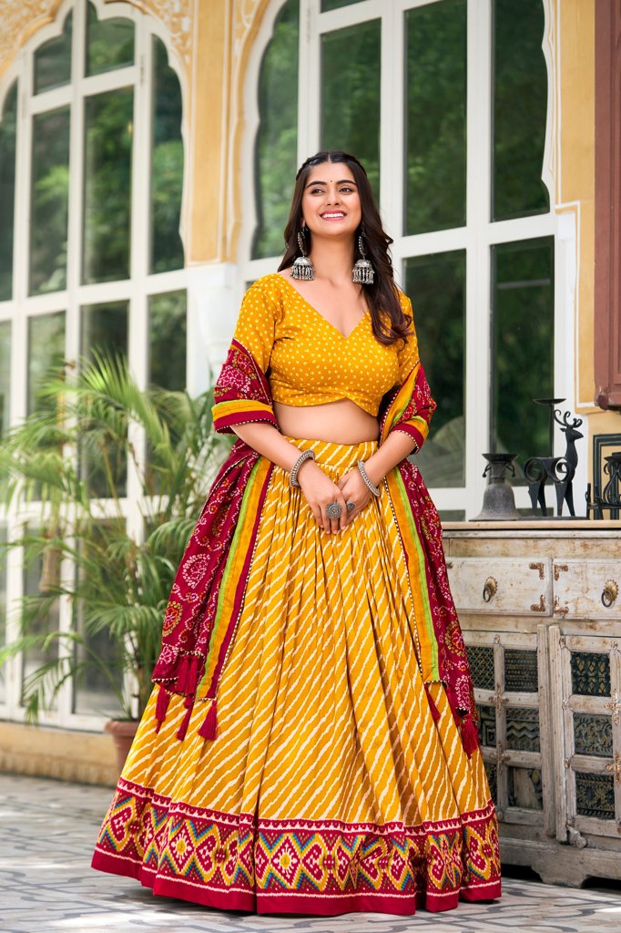 Bright yellow Tussar silk lehenga set with Leheriya pattern and Patola border, perfect for weddings.