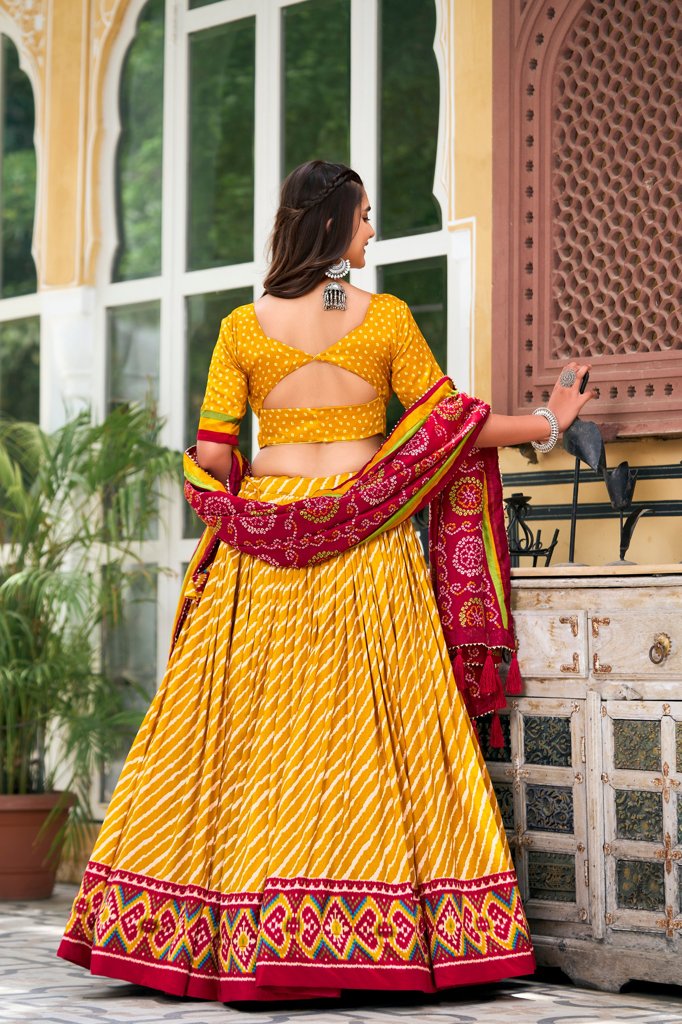 Elegant yellow Tussar silk lehenga with Leheriya design and traditional Patola border, ideal for Indian ceremonies.