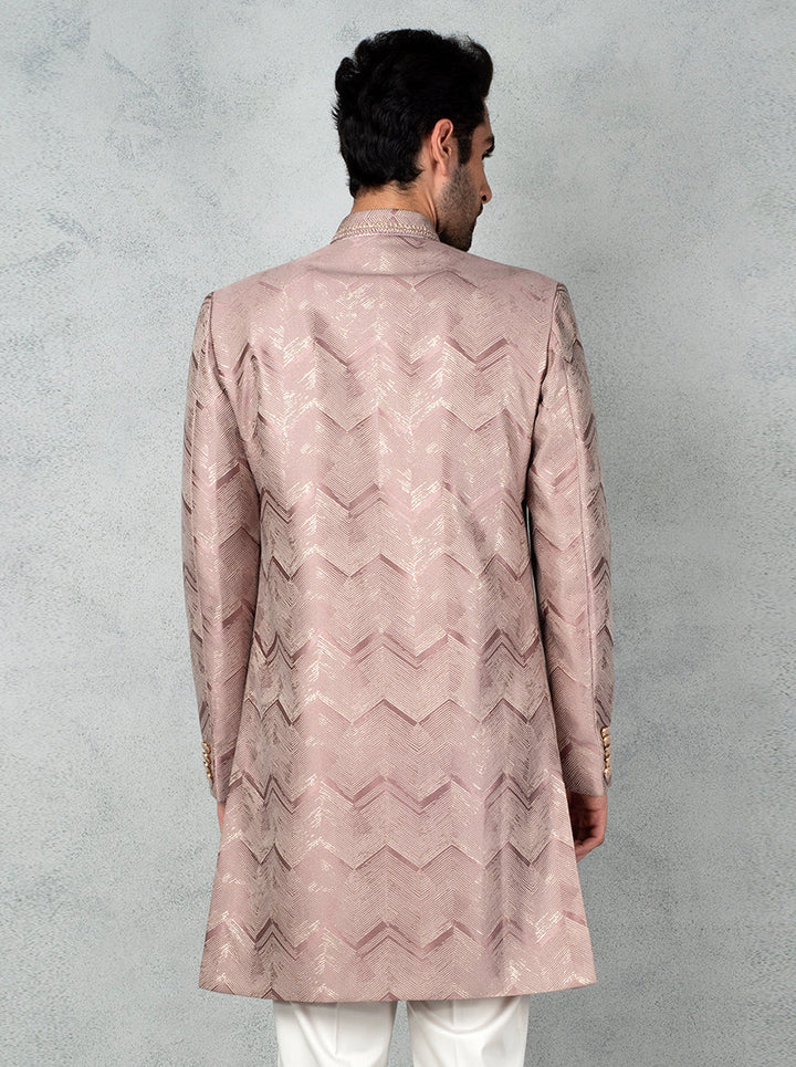 Men's ethnic wear in onion pink with chevron jacquard fabric, metal brooch, and classic straight cut.