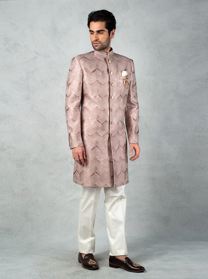 Trendy onion pink Indo Western for men, complete with metal brooch, mandarin collar, and slim fit pants.