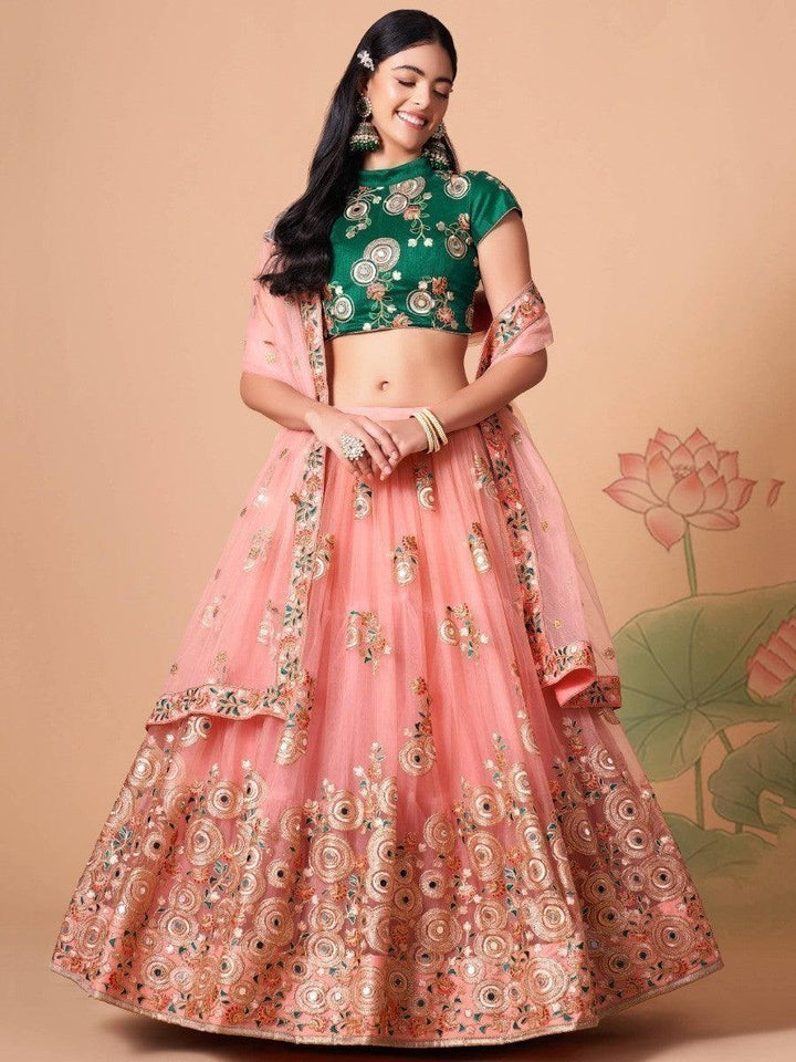 Peach net lehenga choli with mirror work and sequin details.