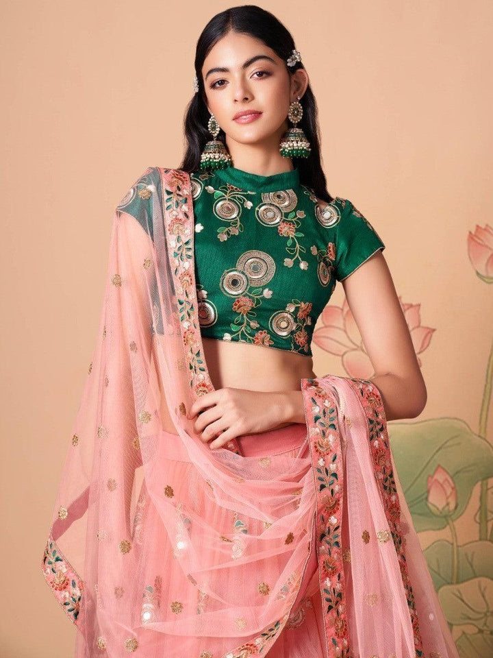 Bridal peach lehenga with matching green choli and dupatta.