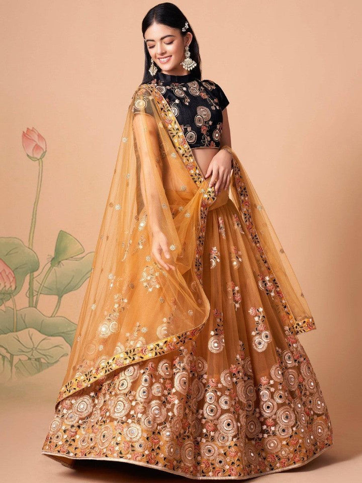 Elegant gold lehenga with matching black choli and mirror work.