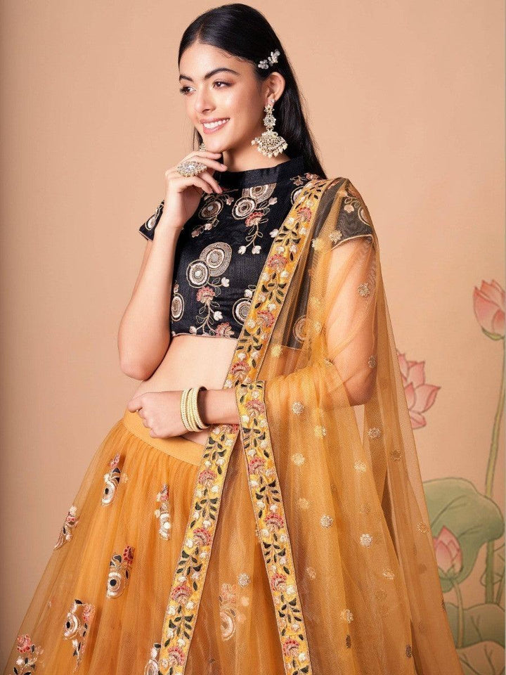 Gold net lehenga with black embroidered choli for special occasions.