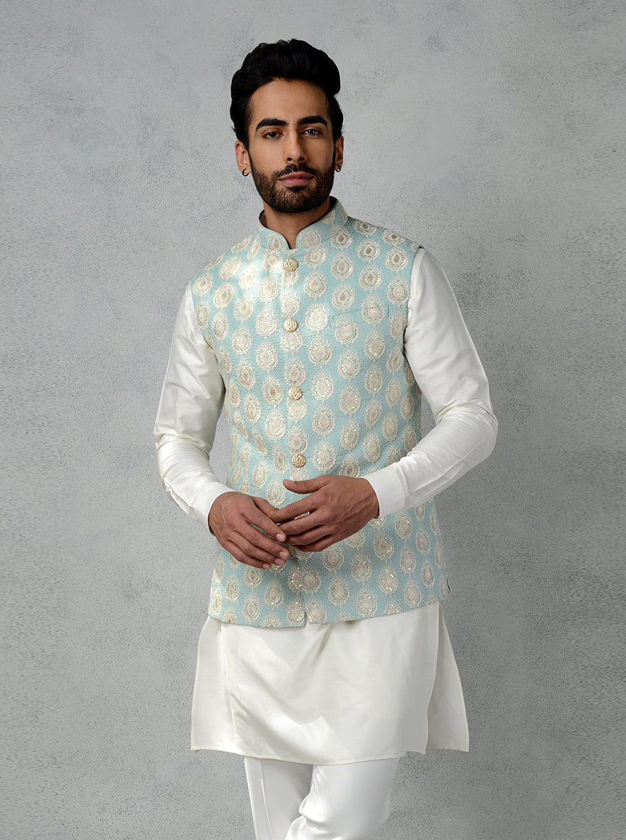 Discover this aqua green Mysur silk bandhgala jacket with retro floral embroidery and golden button detailing.